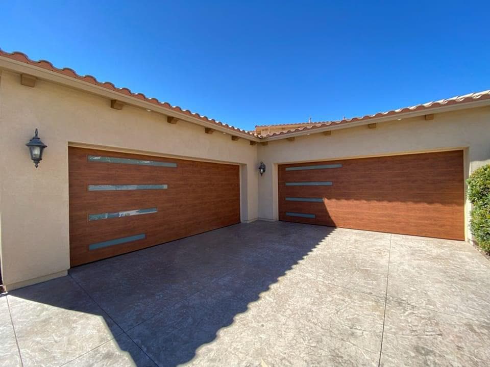 Twin wood-look garage doors on a corner-lot home under a blue sky