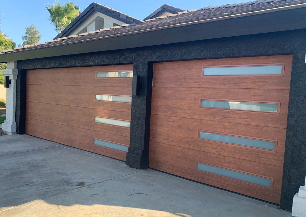 Two matching wood-look garage doors with vertical frosted glass strips