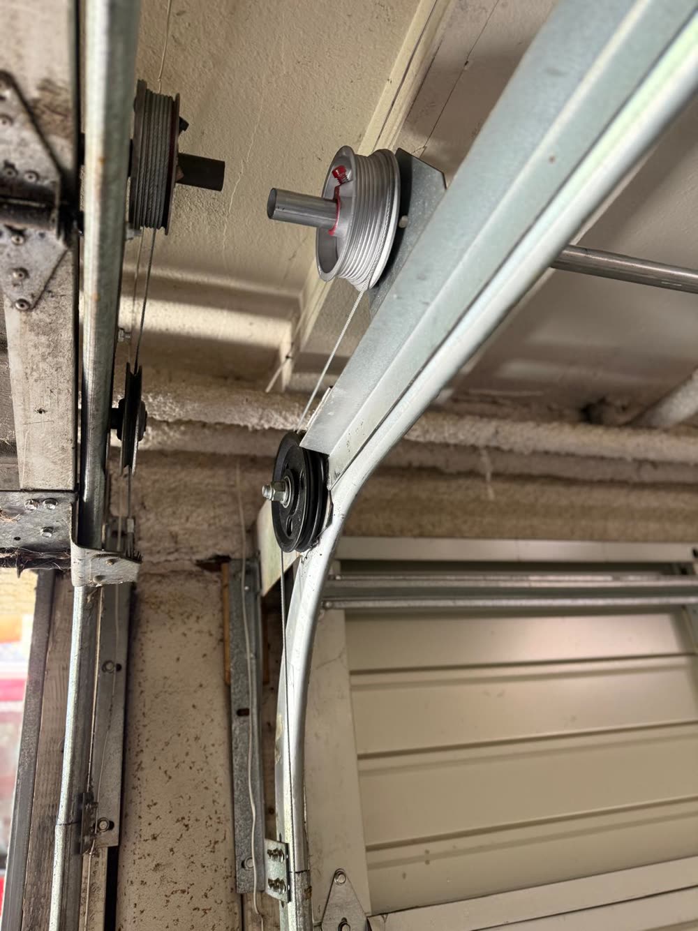 Brand-new cable drum installed on a garage door torsion shaft