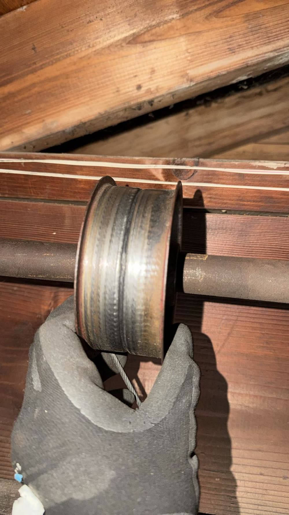 Worn garage door cable drum with grooves polished smooth, before replacement